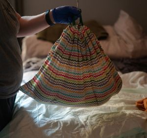 A colorful striped sun hat with zigzag patterns in coral and blue tones on a white surface.