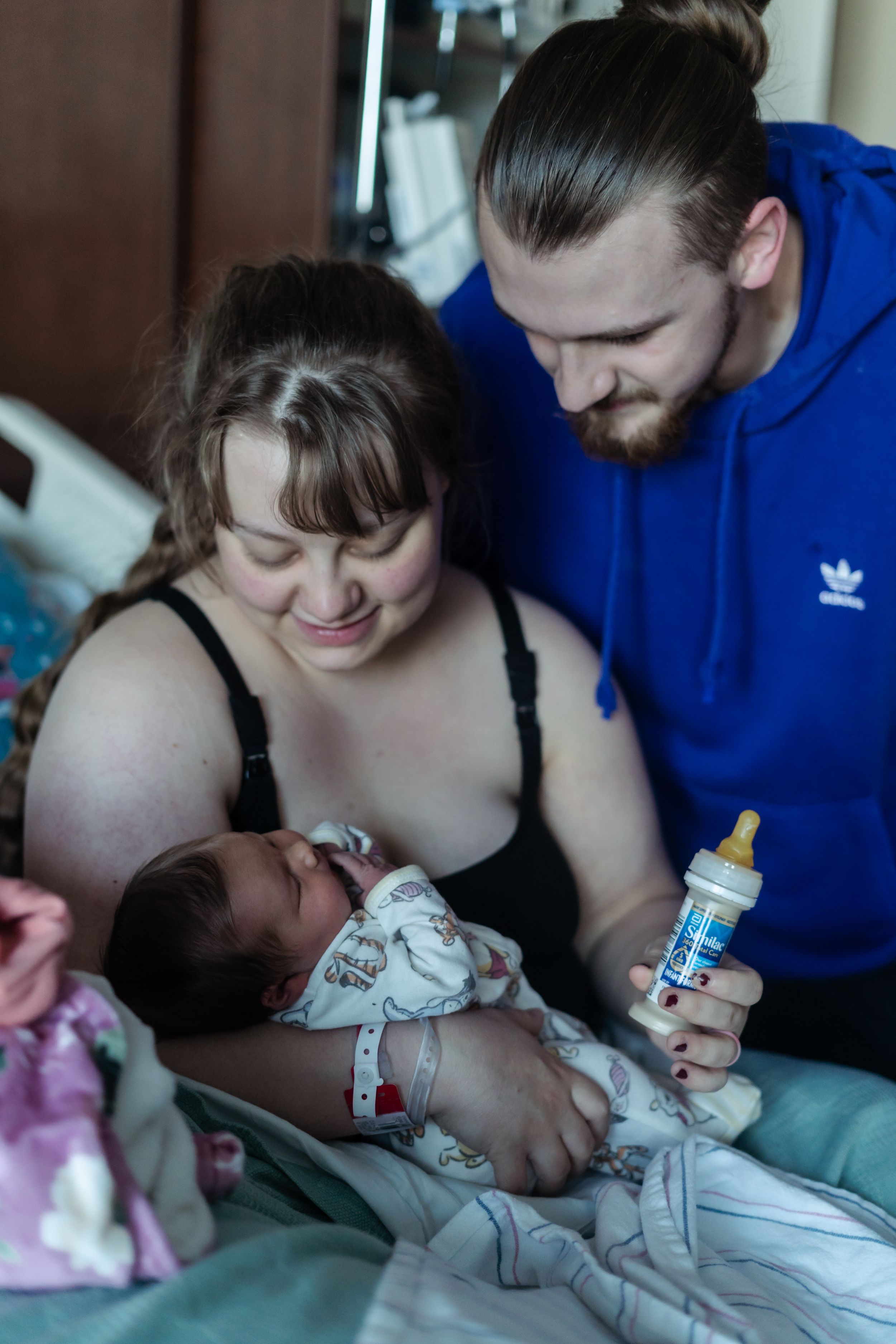A series of tender moments showing parents feeding a newborn baby with a bottle in a dimly lit room.