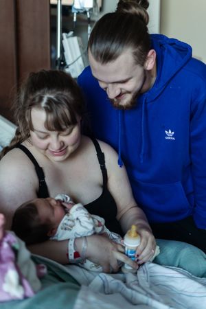 A series of tender moments showing parents feeding a newborn baby with a bottle in a dimly lit room.