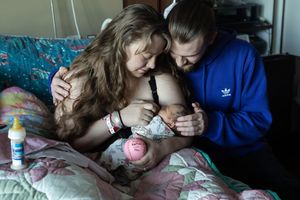 A gentle moment of care and nurturing in a hospital room setting.