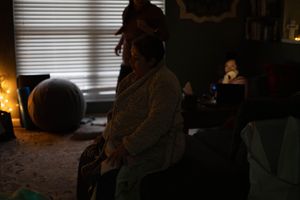 A person in a dark room uses a glowing phone screen, creating a moody atmospheric lighting effect.