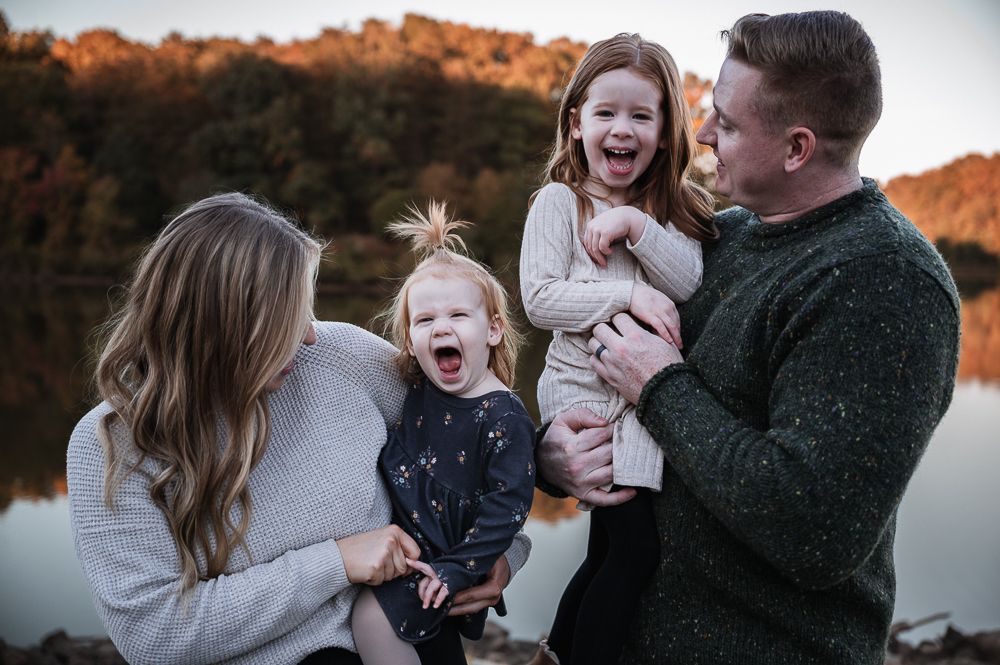 A candid family moment captured outdoors with everyone laughing together during sunset in Stafford VA.