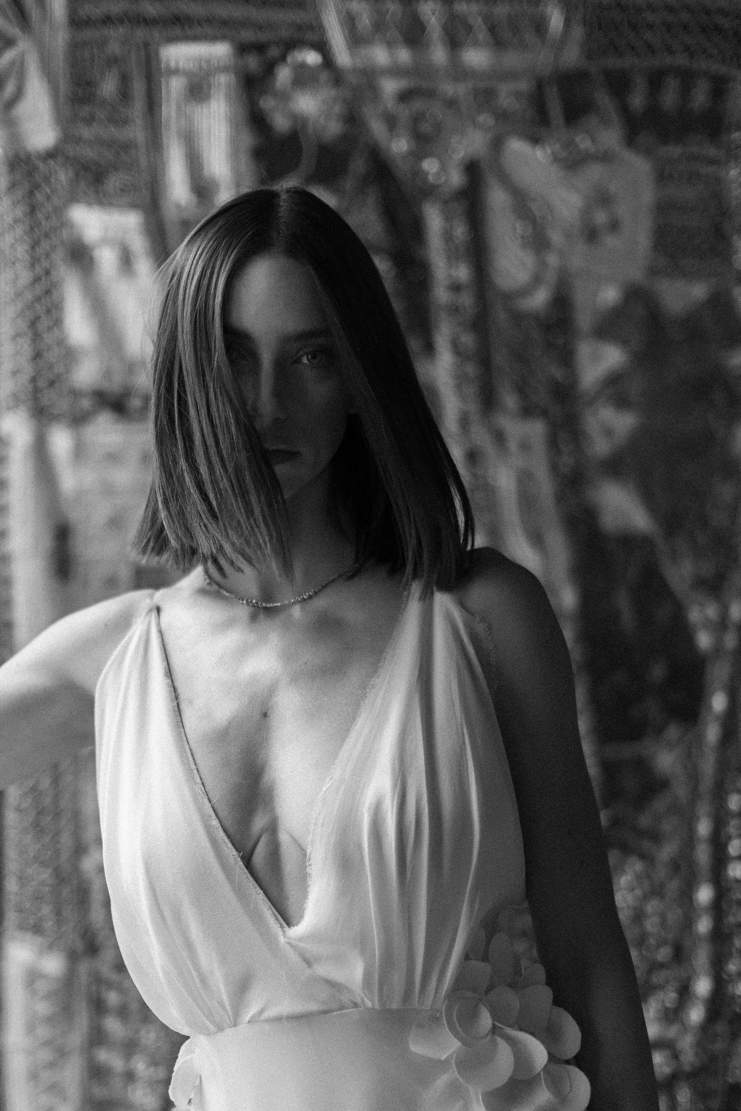 Artistic black and white photos of person in flowing white dress moving through shadowy forest setting.