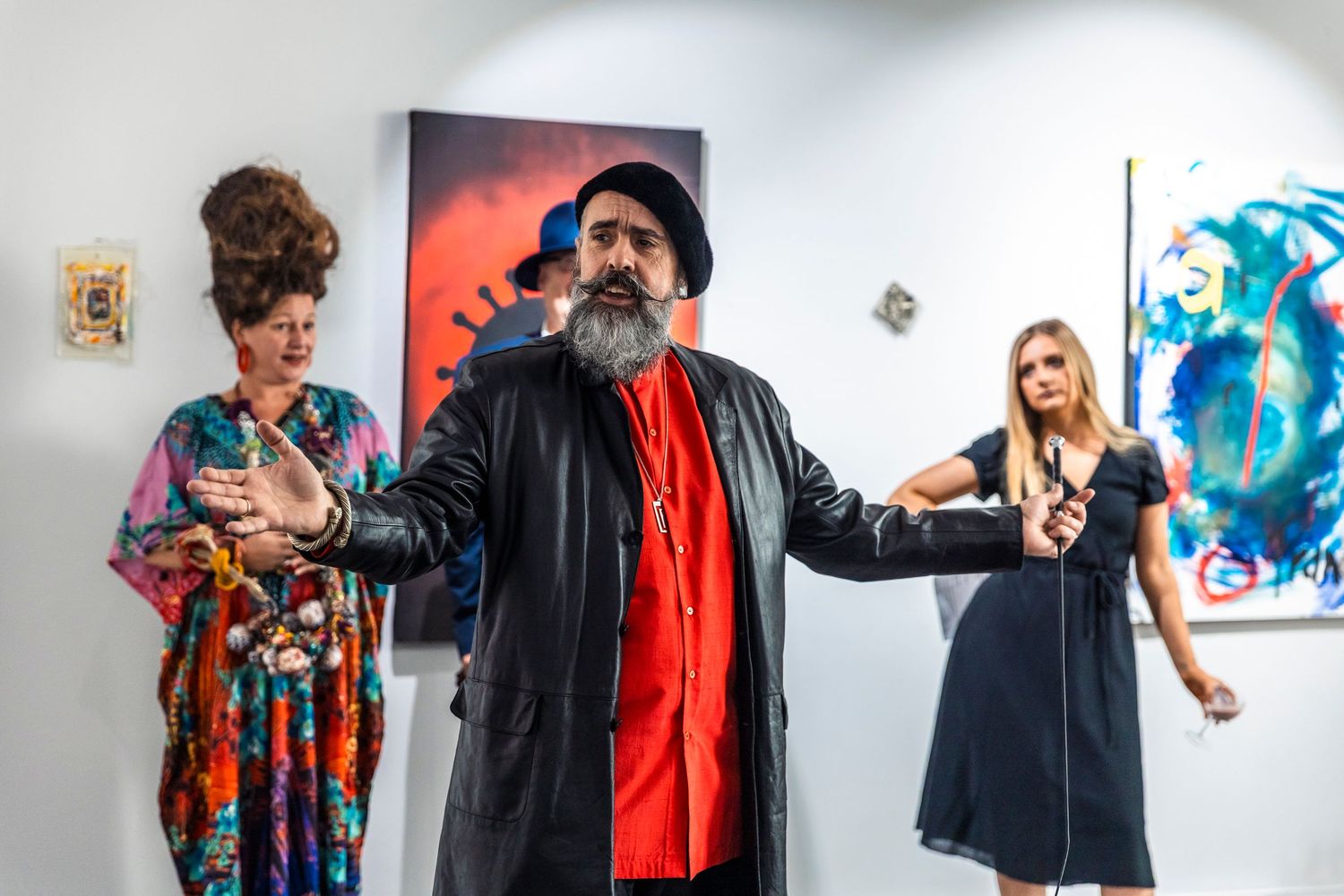 A series of film still photos showing people wearing colorful jackets and artistic clothing against white walls and artwork.