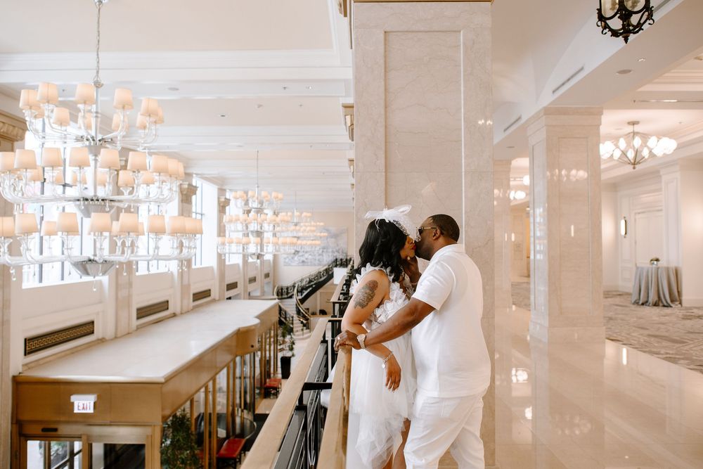 Wedding couple sharing intimate moment on elegant staircase with modern interior design.