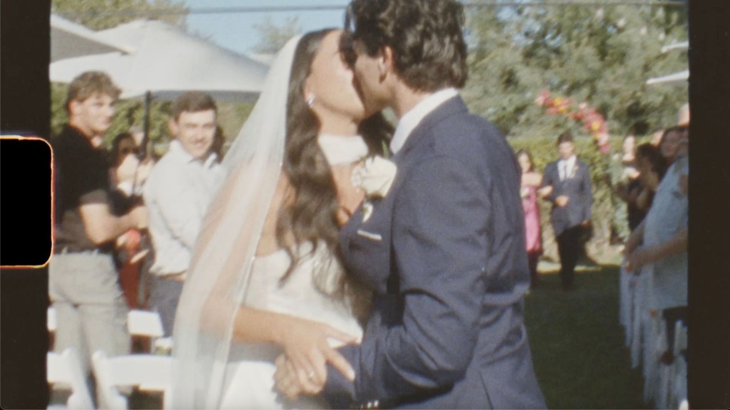 Wedding ceremony guests gather outdoors during a joyful celebration in a natural setting.