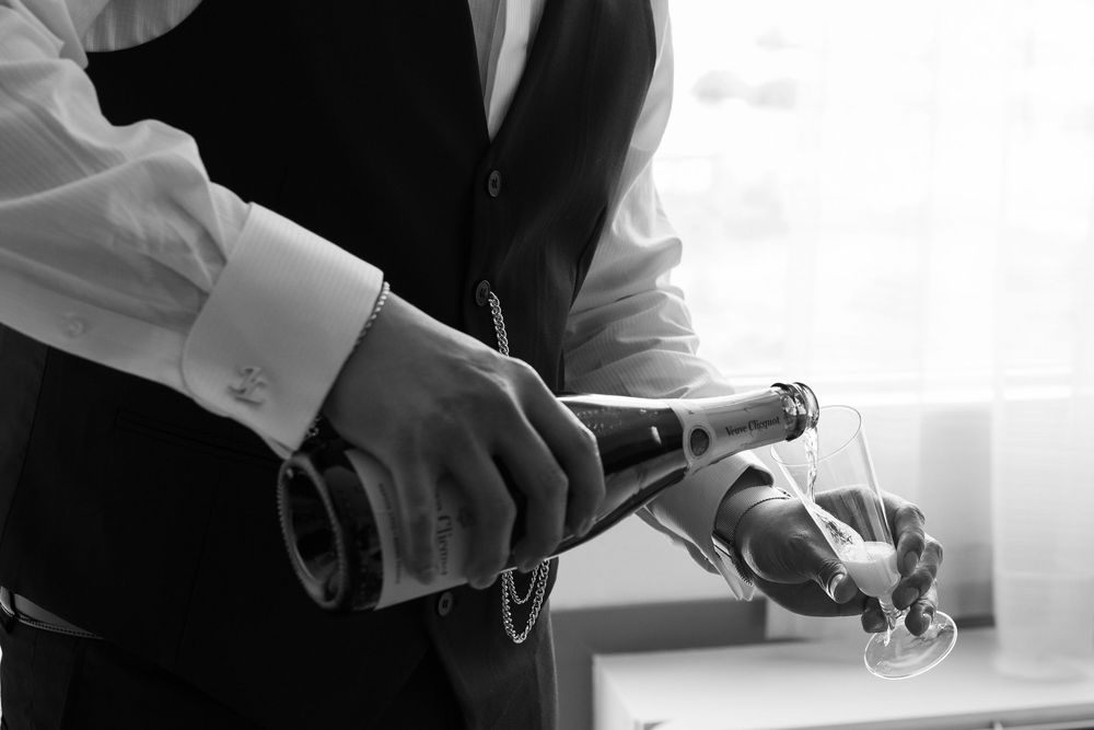 Professional pouring wine into a glass at a fine dining restaurant.