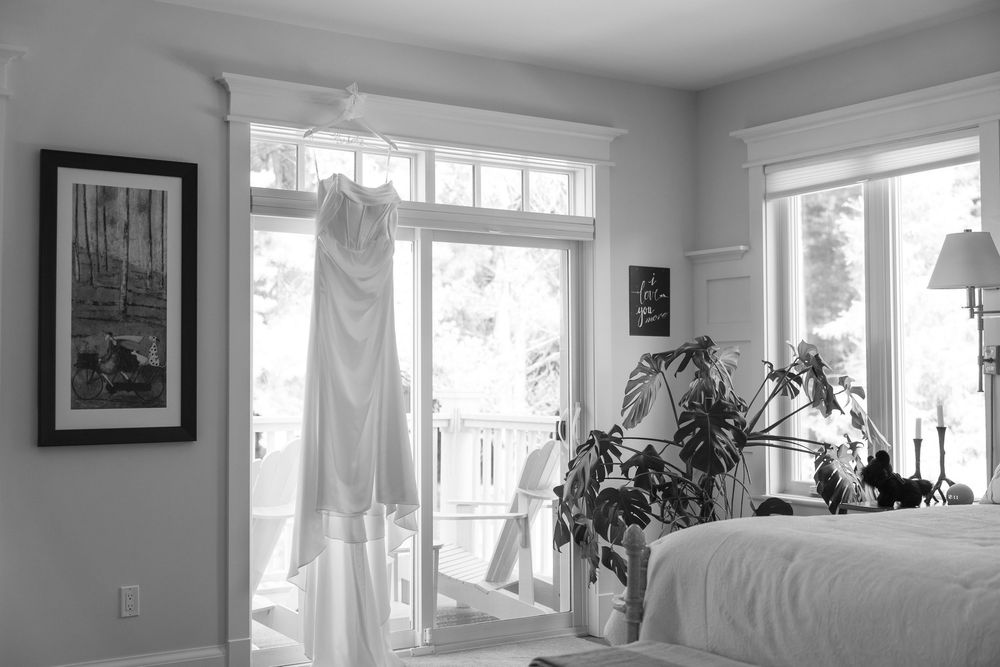 A bright, airy room with large windows, houseplants, and white curtains creates a serene living space.