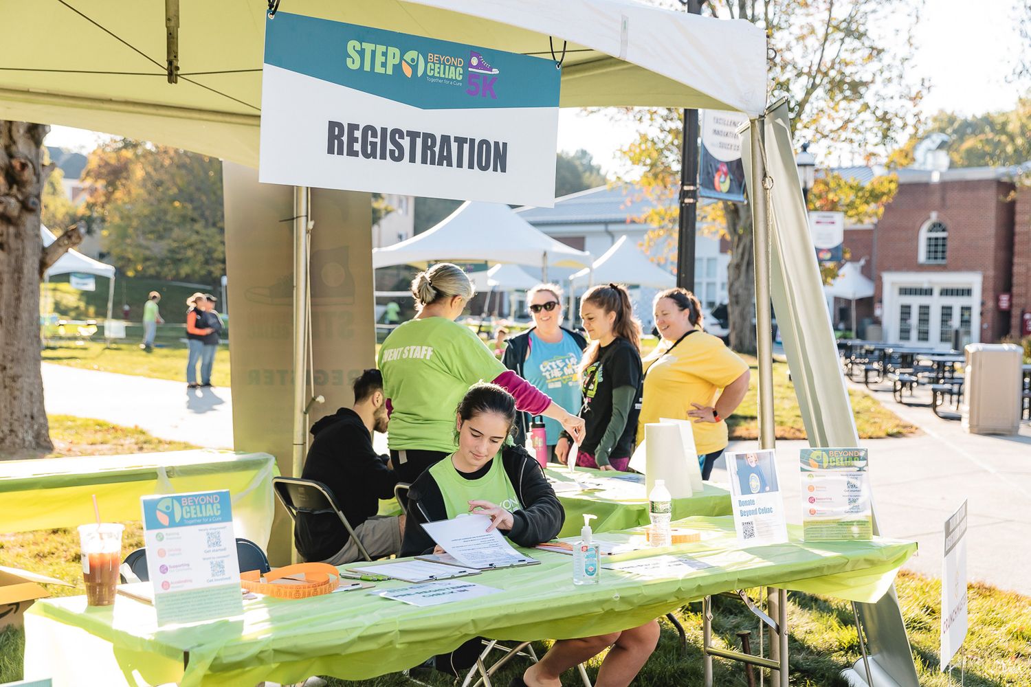 Registration booth with green table and banner at an outdoor community event.