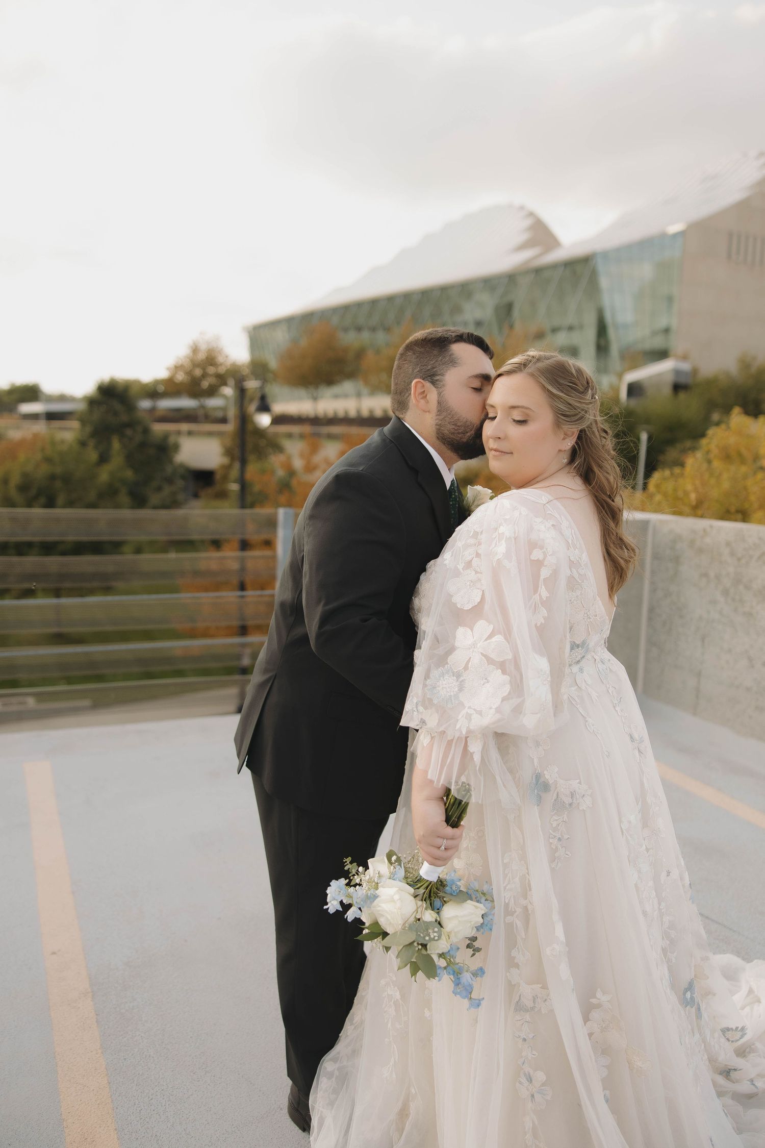 Romantic wedding couple shares intimate moments during outdoor photo session with mountain backdrop.