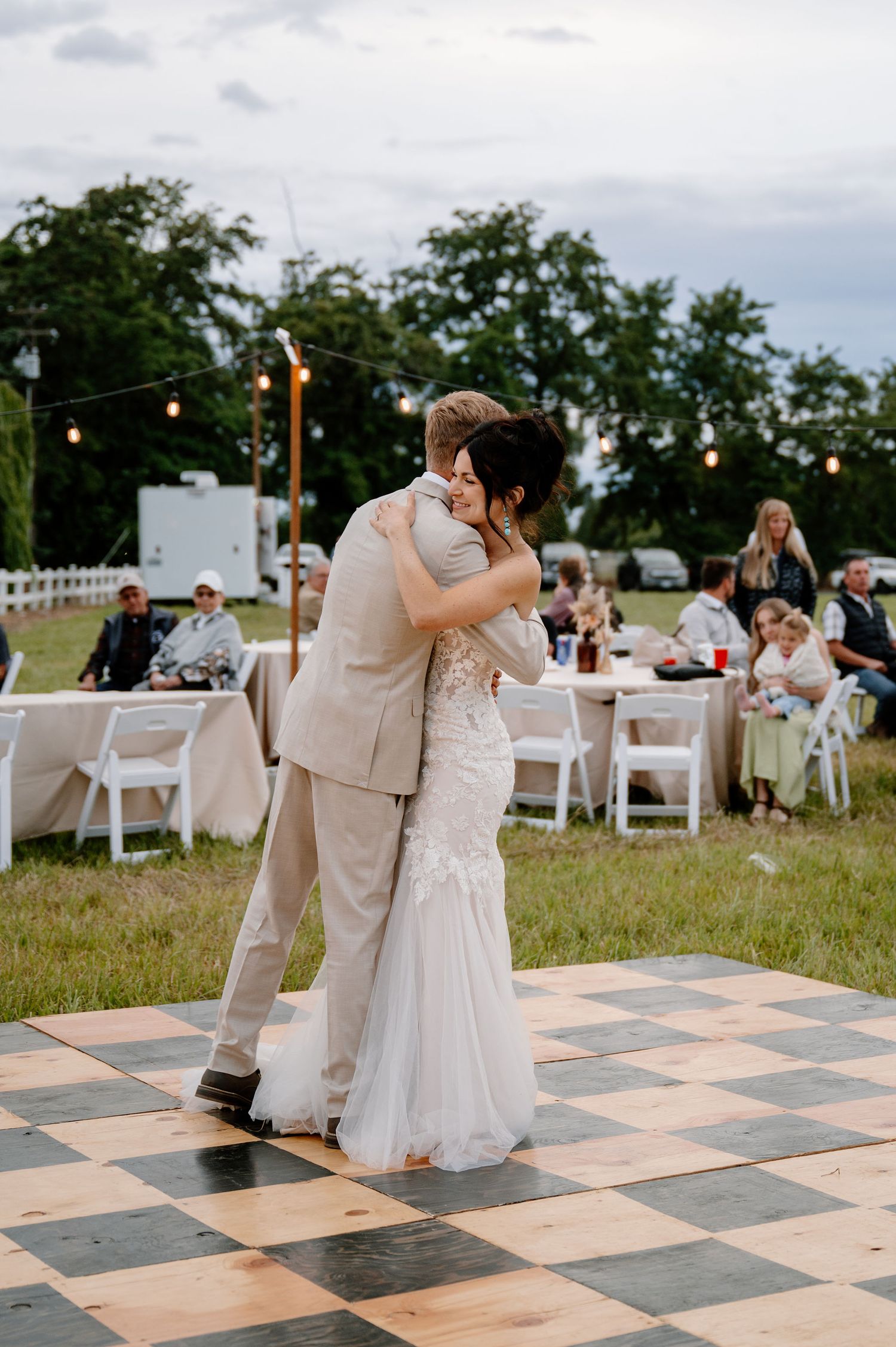 Overcast outdoor wedding reception with a checkered dance floor
