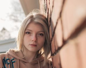 Soft natural light portrait with shadows creating an artistic effect.