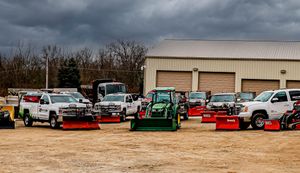 Wide view of industrial lot with trucks and equipment parked in rows.
