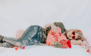 Person reclining on white background with red accents in artistic poses.