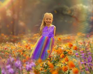 Colorful flower garden with orange blooms and purple flowers in soft focus.