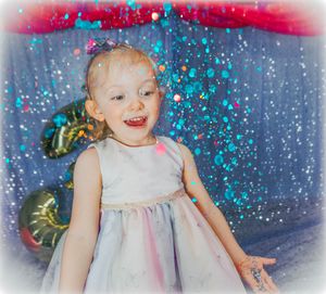 White dress with sparkly blue and pink glitter effects in celebratory setting.