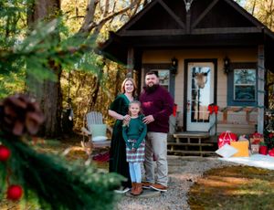 Family enjoying a festive outdoor photo session with Christmas decorations and natural lighting in a backyard setting.