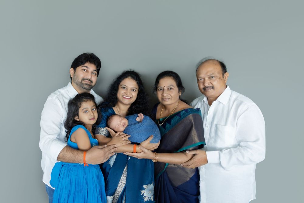 A group of people wearing blue and white clothing pose together for a series of casual family portraits.