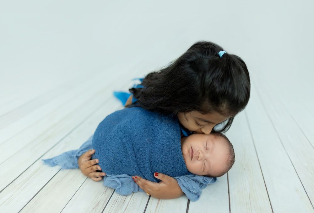 A person wearing blue denim lies down on a white wooden floor while sleeping peacefully.