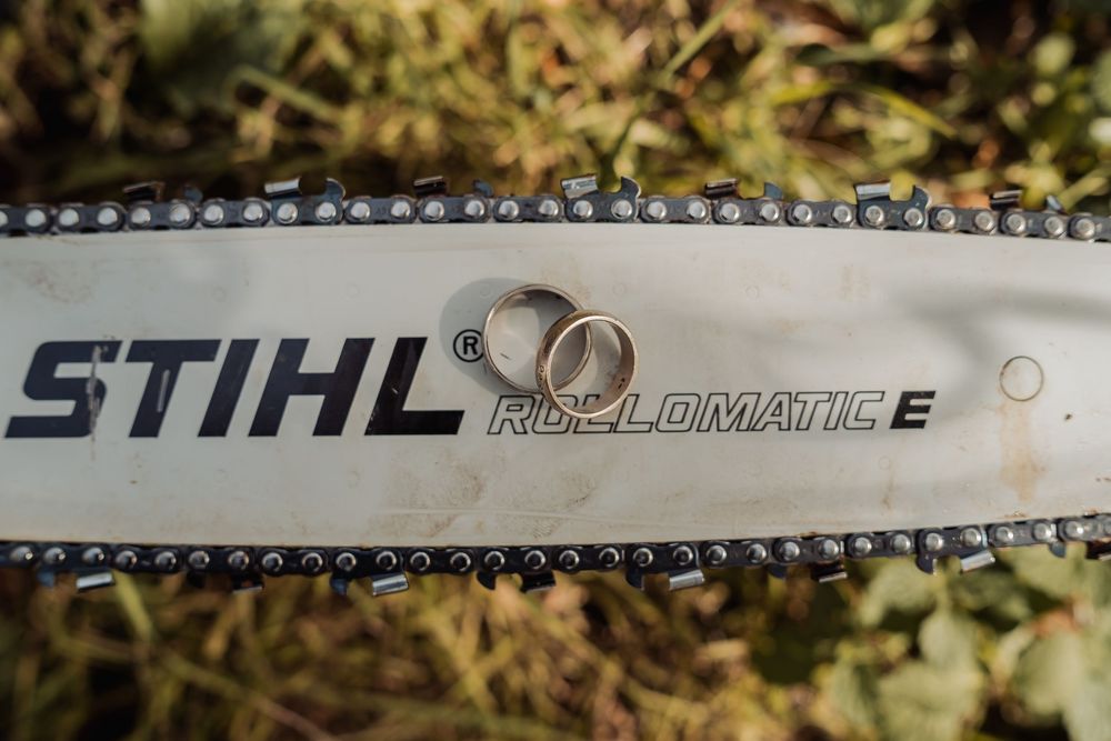Close-up view of a chainsaw bar with STIHL branding and chain detail in outdoor setting.