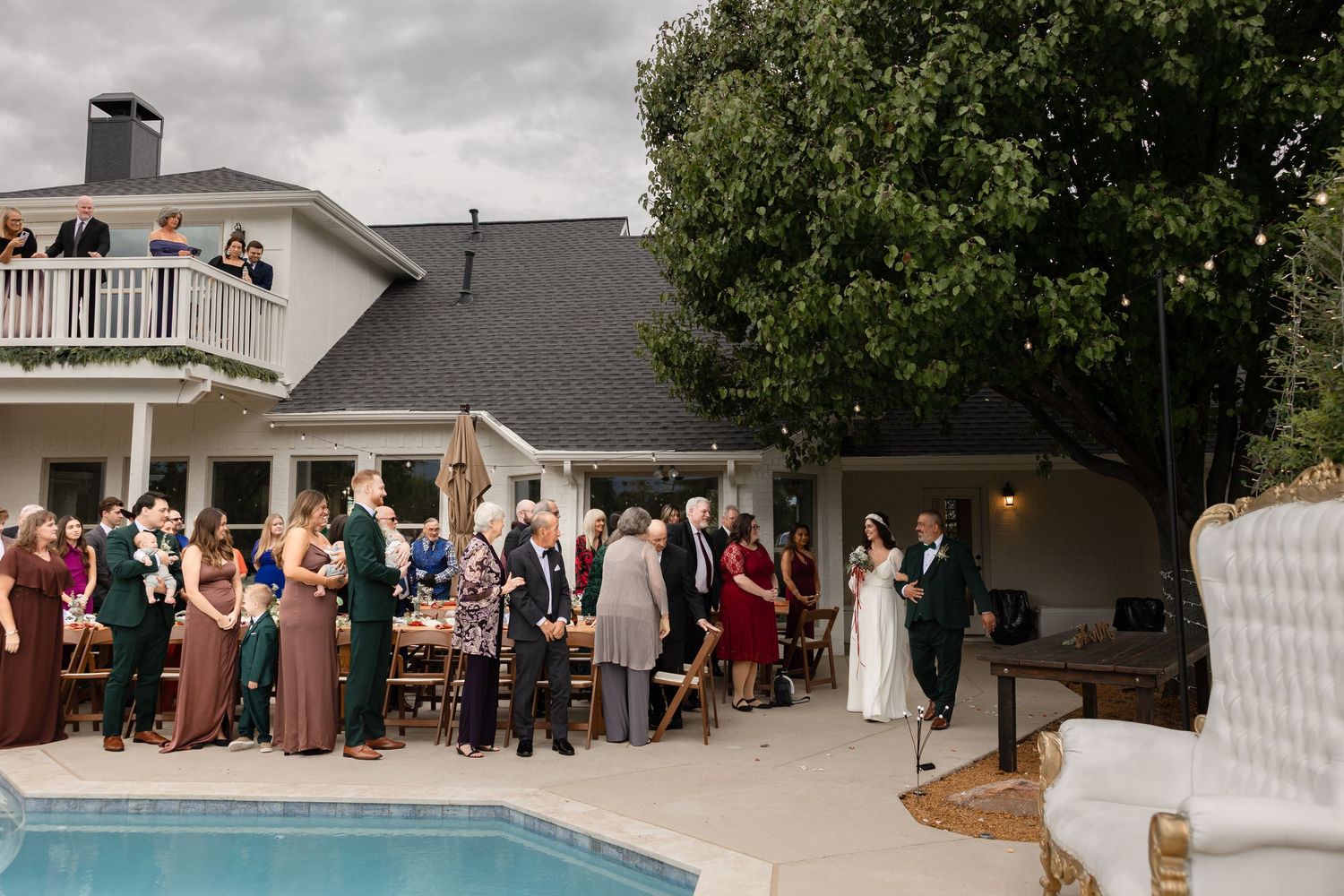 Wedding guests gather on an outdoor patio during a summer celebration at an elegant venue.