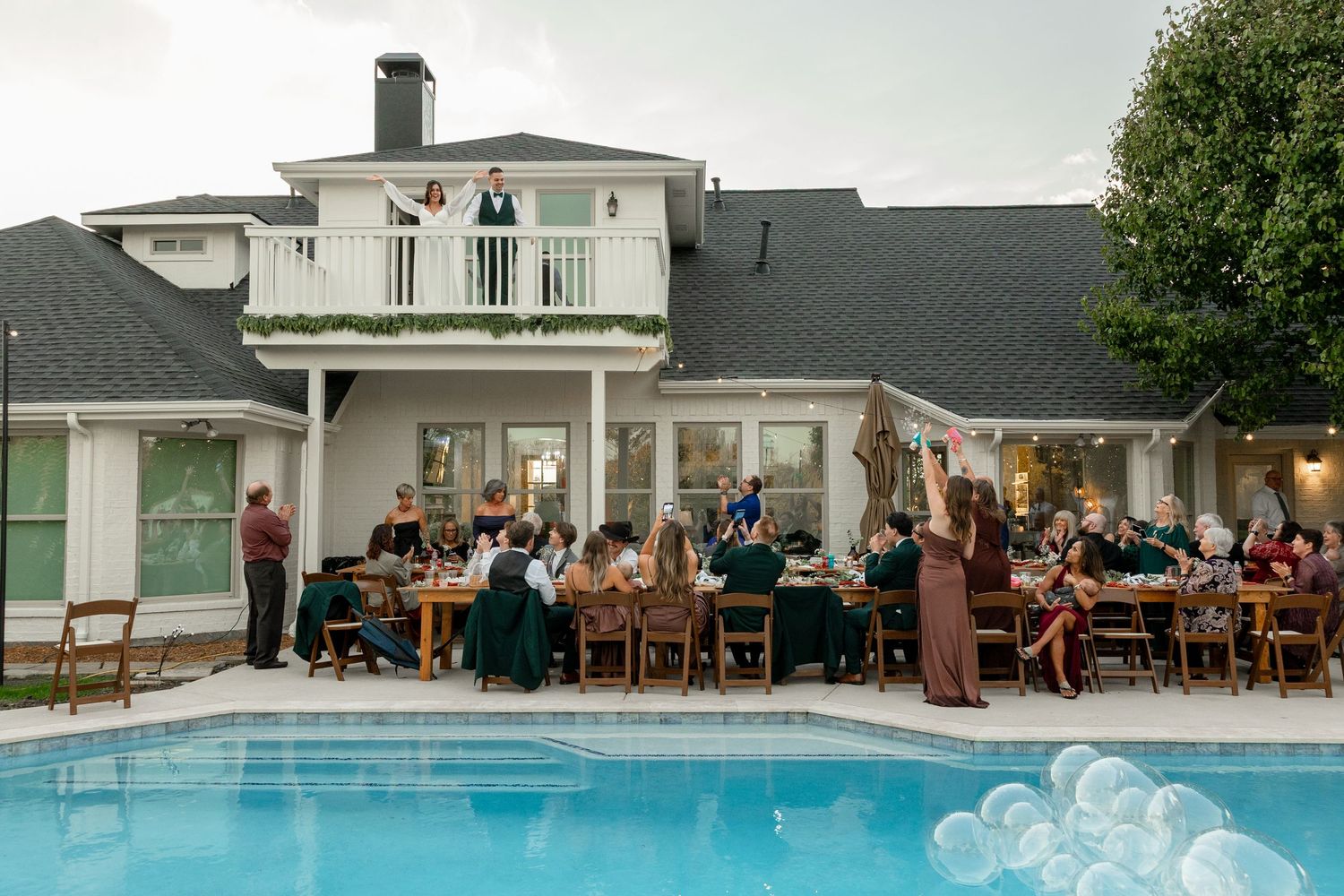 Exterior shots of a modern white building complex with swimming pool and outdoor dining areas at dusk.