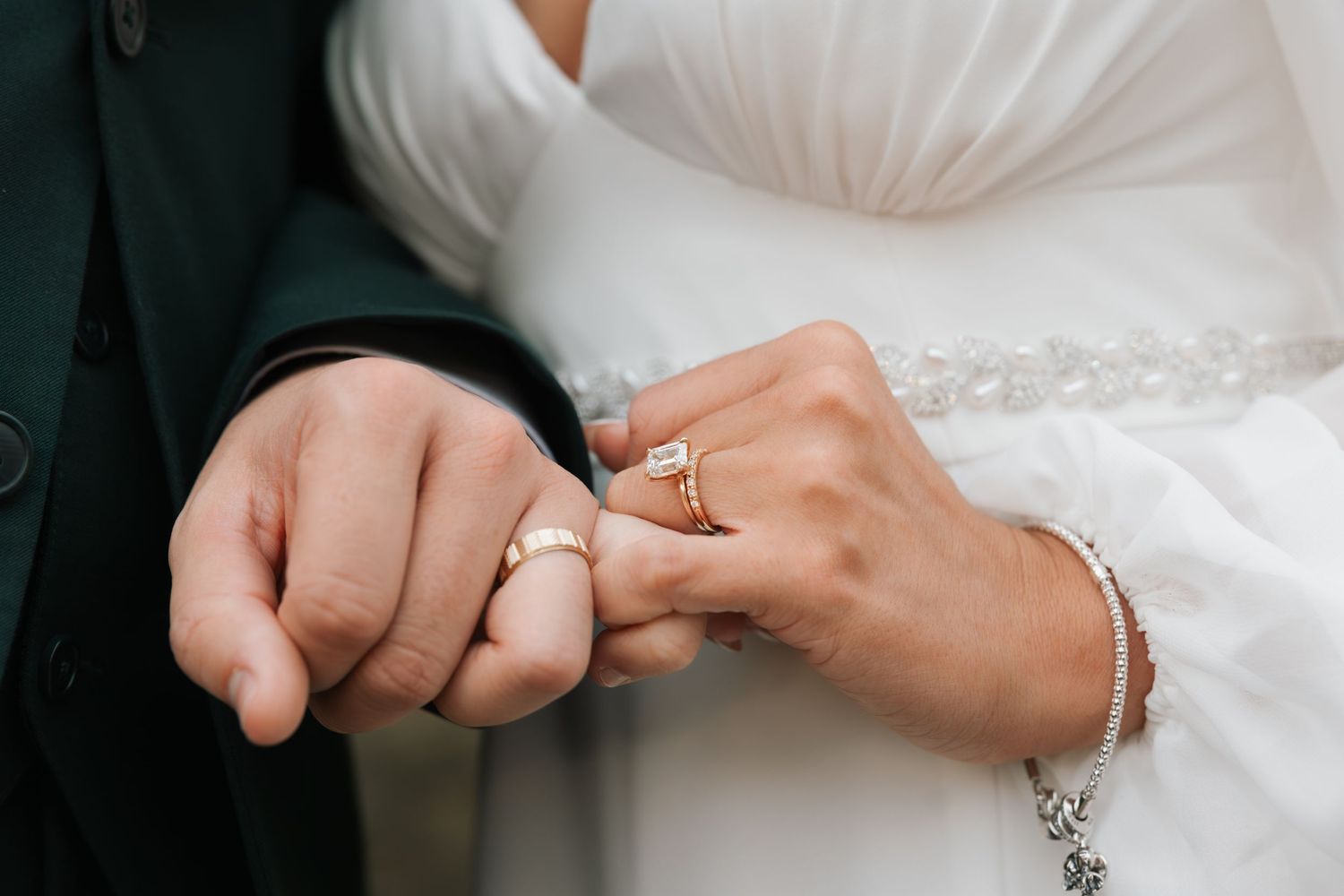 Close-up of hands exchanging wedding rings during a marriage ceremony.