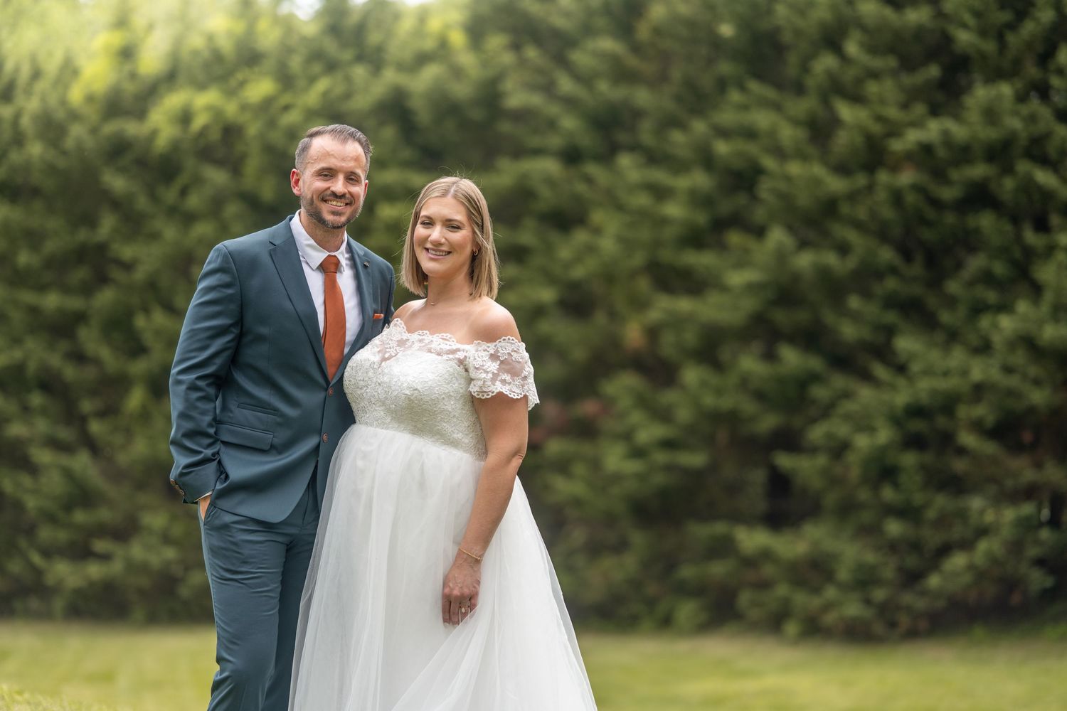 Outdoor wedding portraits captured in a lush green garden setting.