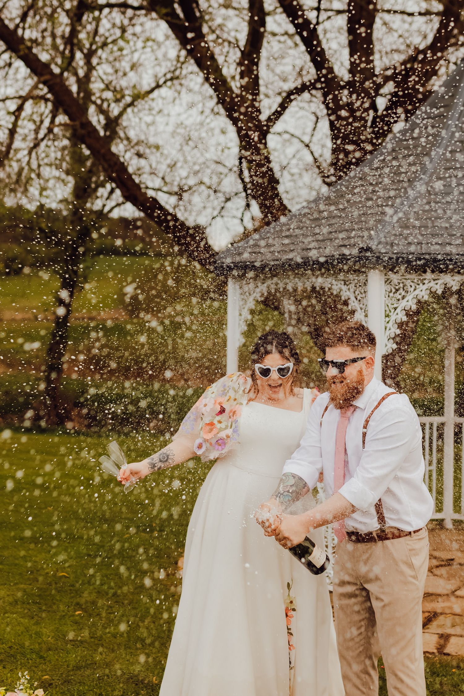 The wedding couple celebrating together with champagne, smiling and toasting.