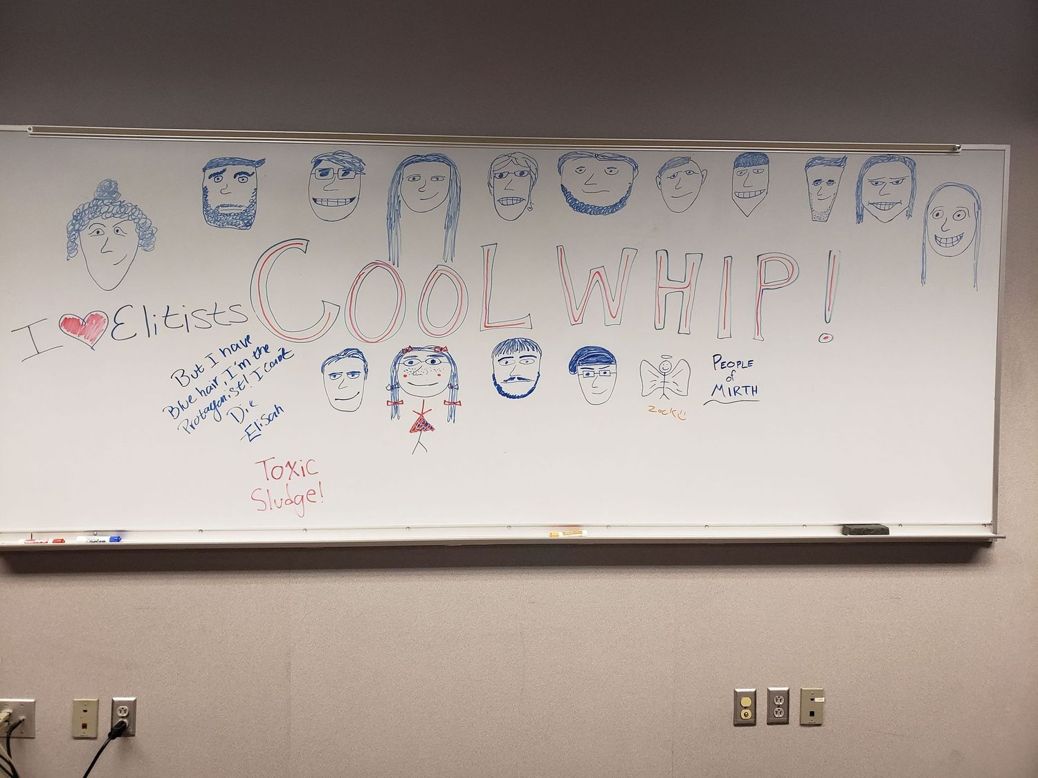 Whiteboard decorated with colorful cartoon faces and Cool Whip text in a classroom setting.
