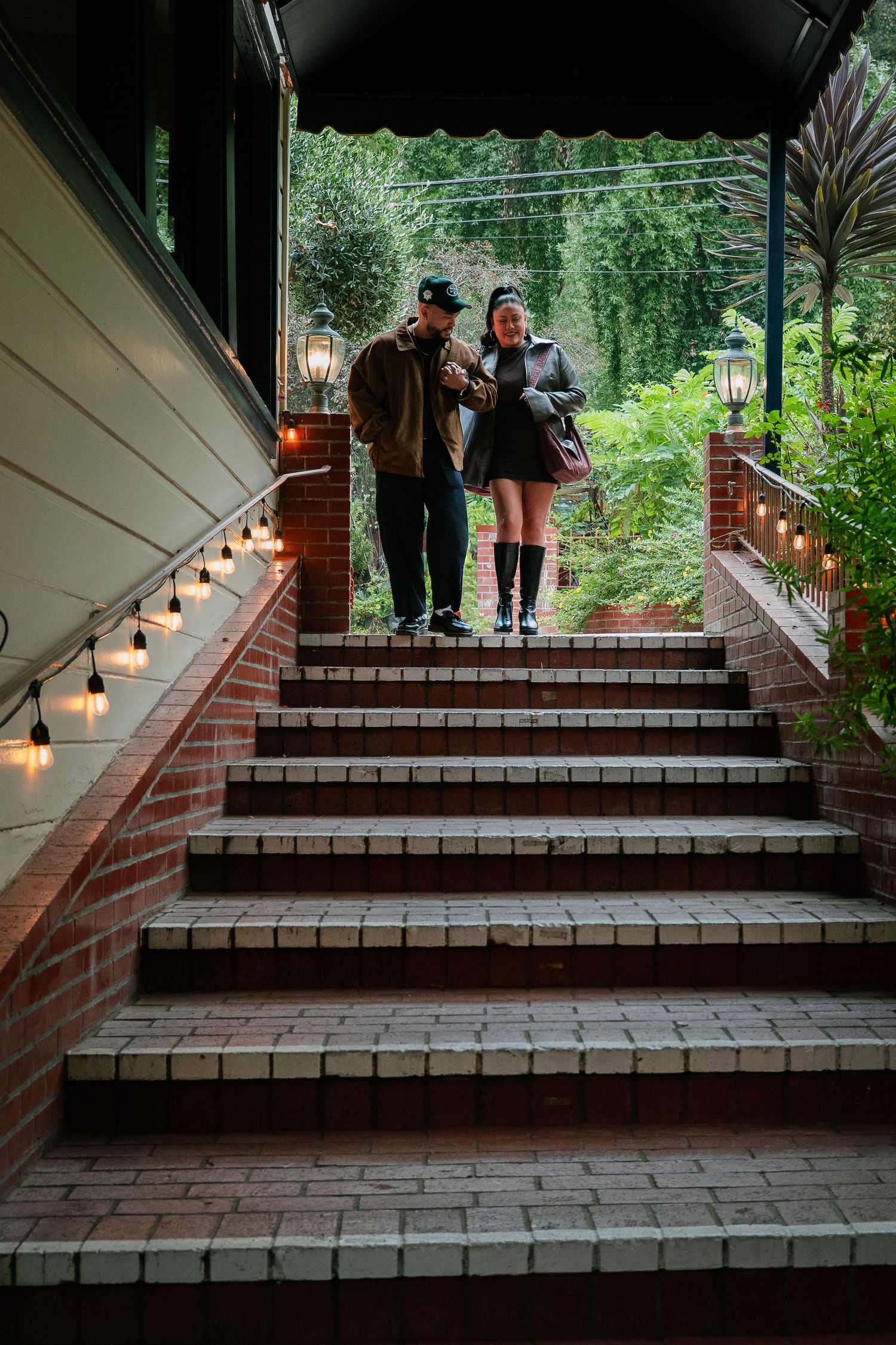 Illuminated brick steps with lanterns create a cozy outdoor walkway at dusk.