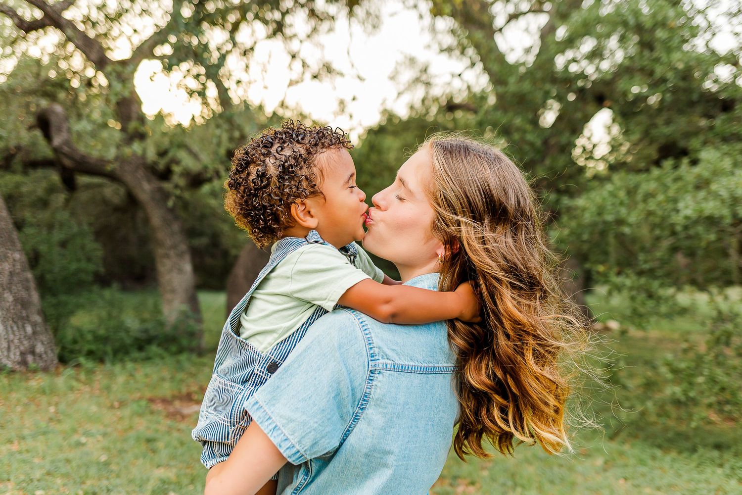 A tender moment shared between parent and child in a sun-dappled garden setting.