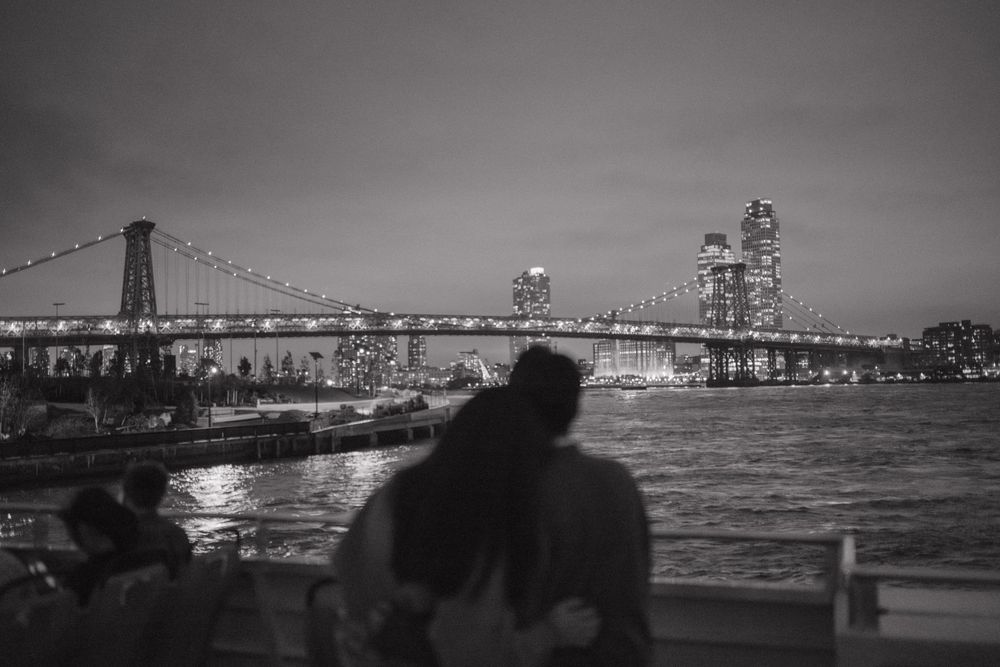 A series of black and white panoramic photographs showing the San Francisco Bay Bridge at night with city lights reflecting on water.
