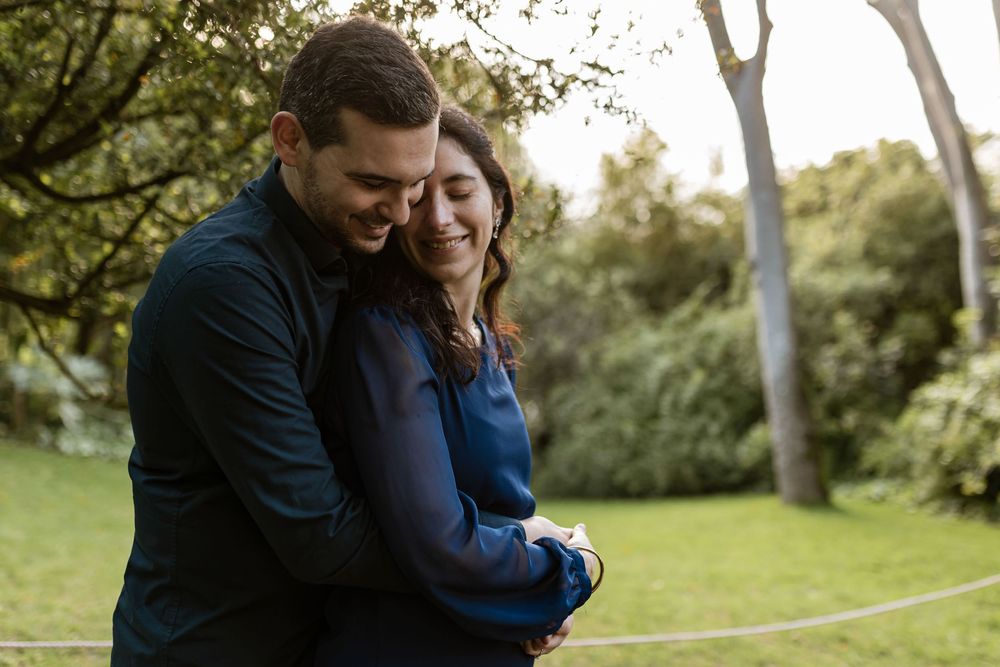 Romantic pre wedding photoshoot in Gulbenkian Garden Lisbon, couple embracing under trees at golden hour
