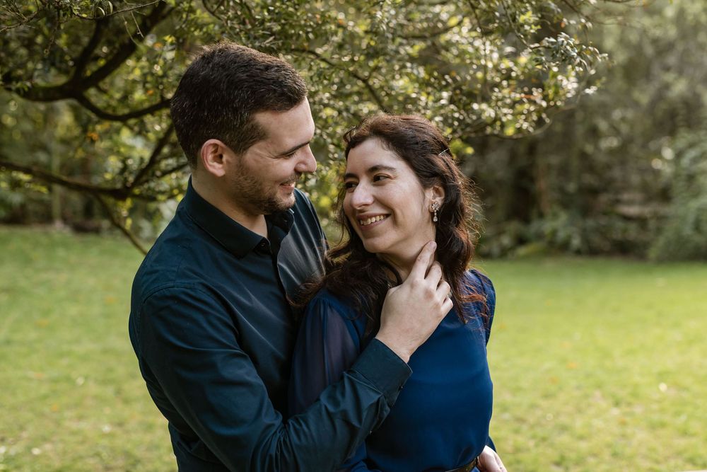Close up of couple smiling at each other during engagement photoshoot in Lisbon botanical garden setting