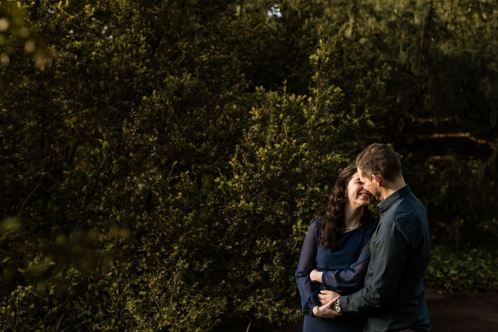 Intimate moment of couple embracing in lush garden during pre wedding session in Gulbenkian Lisbon