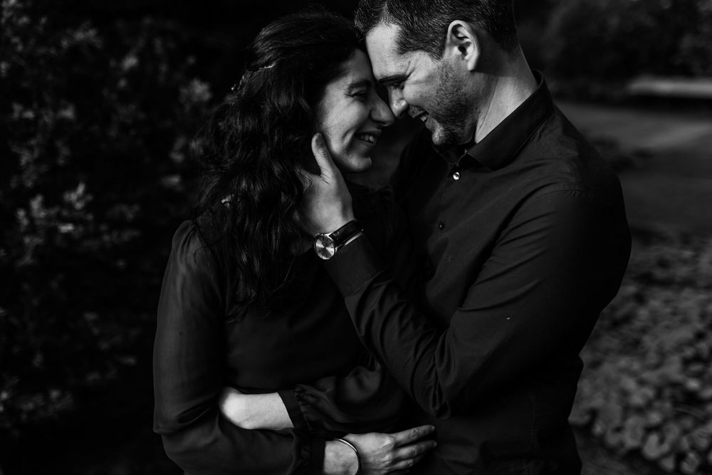 Black and white close up of couple smiling together during engagement session in Gulbenkian Garden