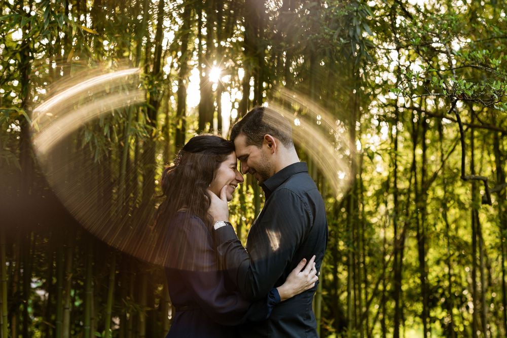 Creative lens flare portrait of couple during golden hour engagement session in Lisbon garden