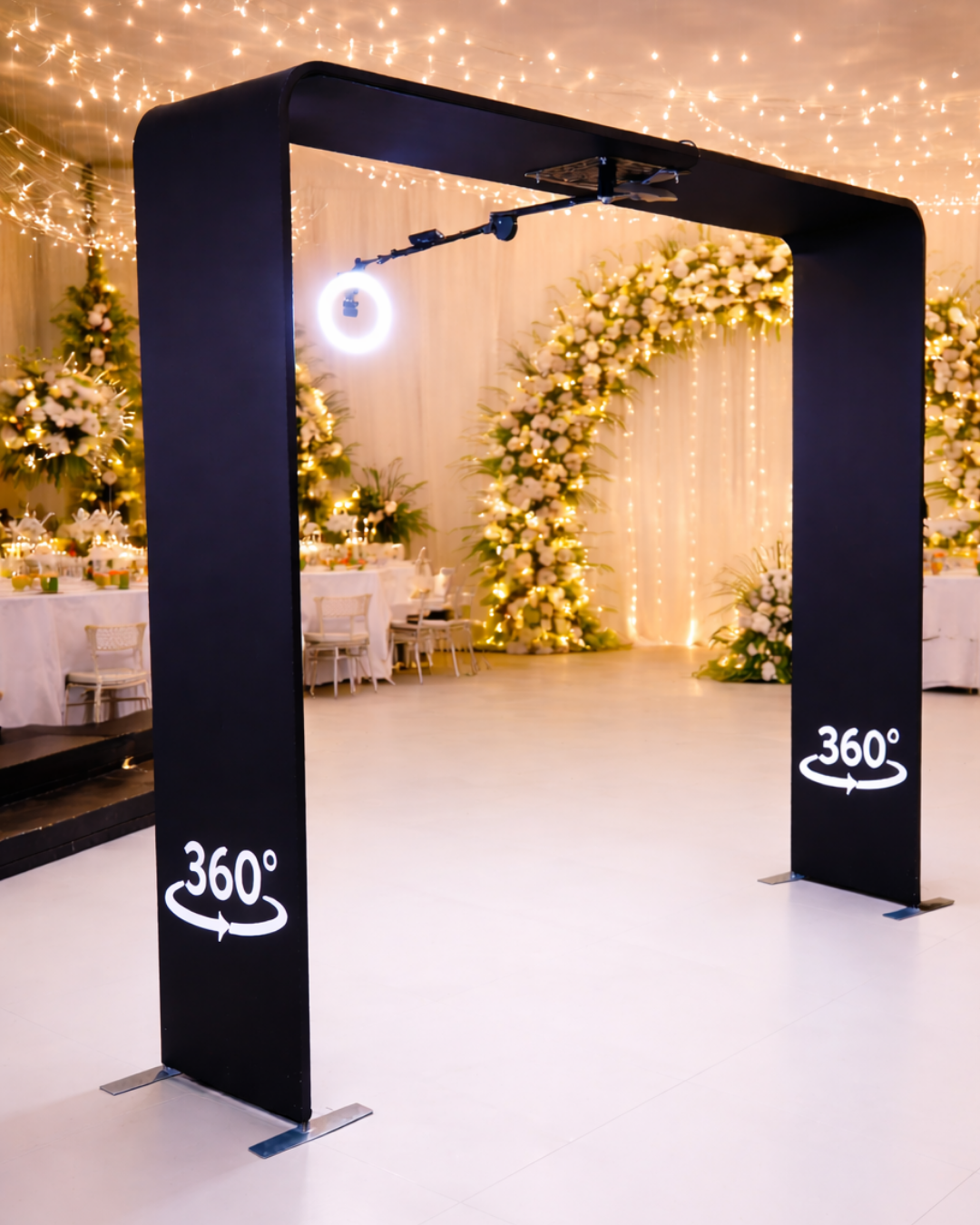 A modern photo booth setup with black dividers and twinkling fairy lights creating an elegant atmosphere at an event venue.