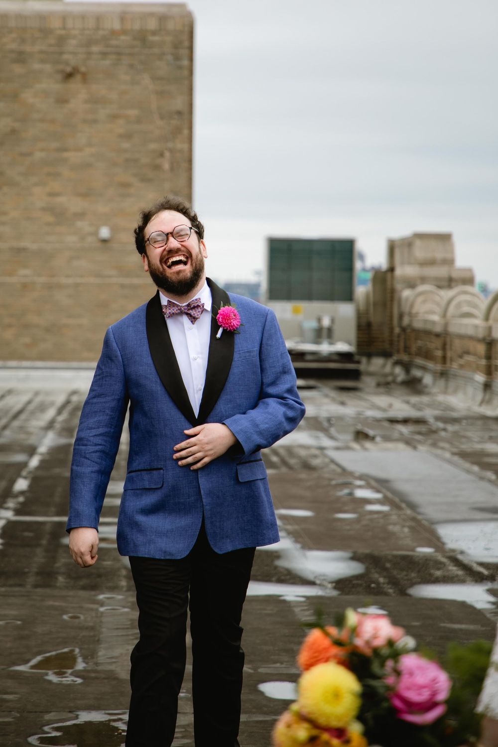 Wedding attire featuring navy blue suit jacket and red boutonniere on rooftop. Bok Building Philadelphia