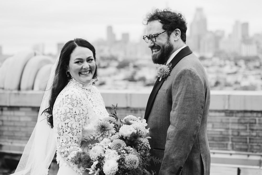Black and white portrait of wedding couple with city skyline backdrop. Bok Building Philadelphia