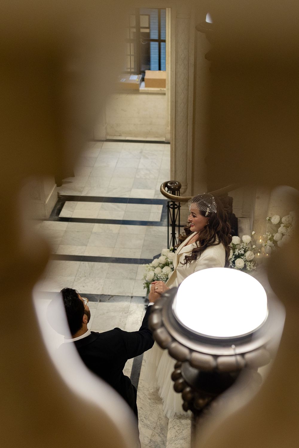 A series of blurred photos showing people viewing artwork through a heart-shaped opening in a wall.