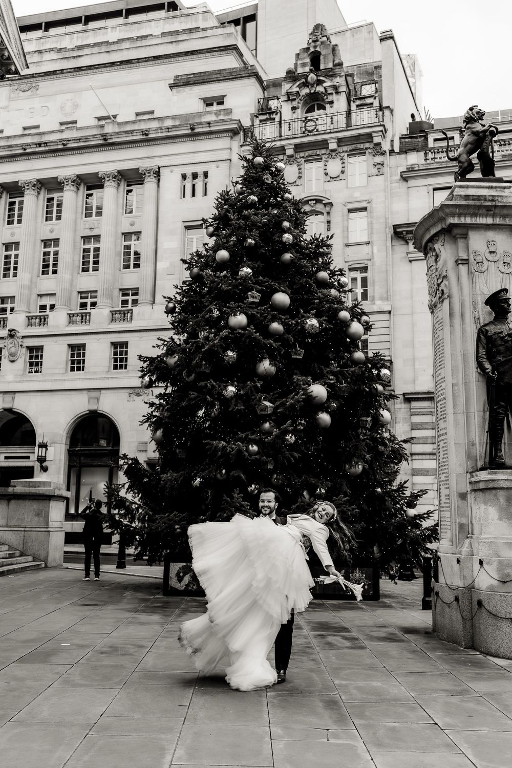 A sequence of black and white photos showing a bride in a flowing dress twirling in front of a grand historic building.