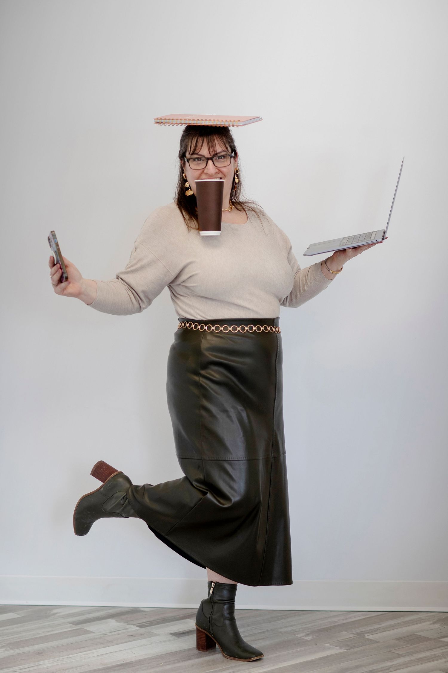 Jacquie balancing a laptop, phone, coffee and a book