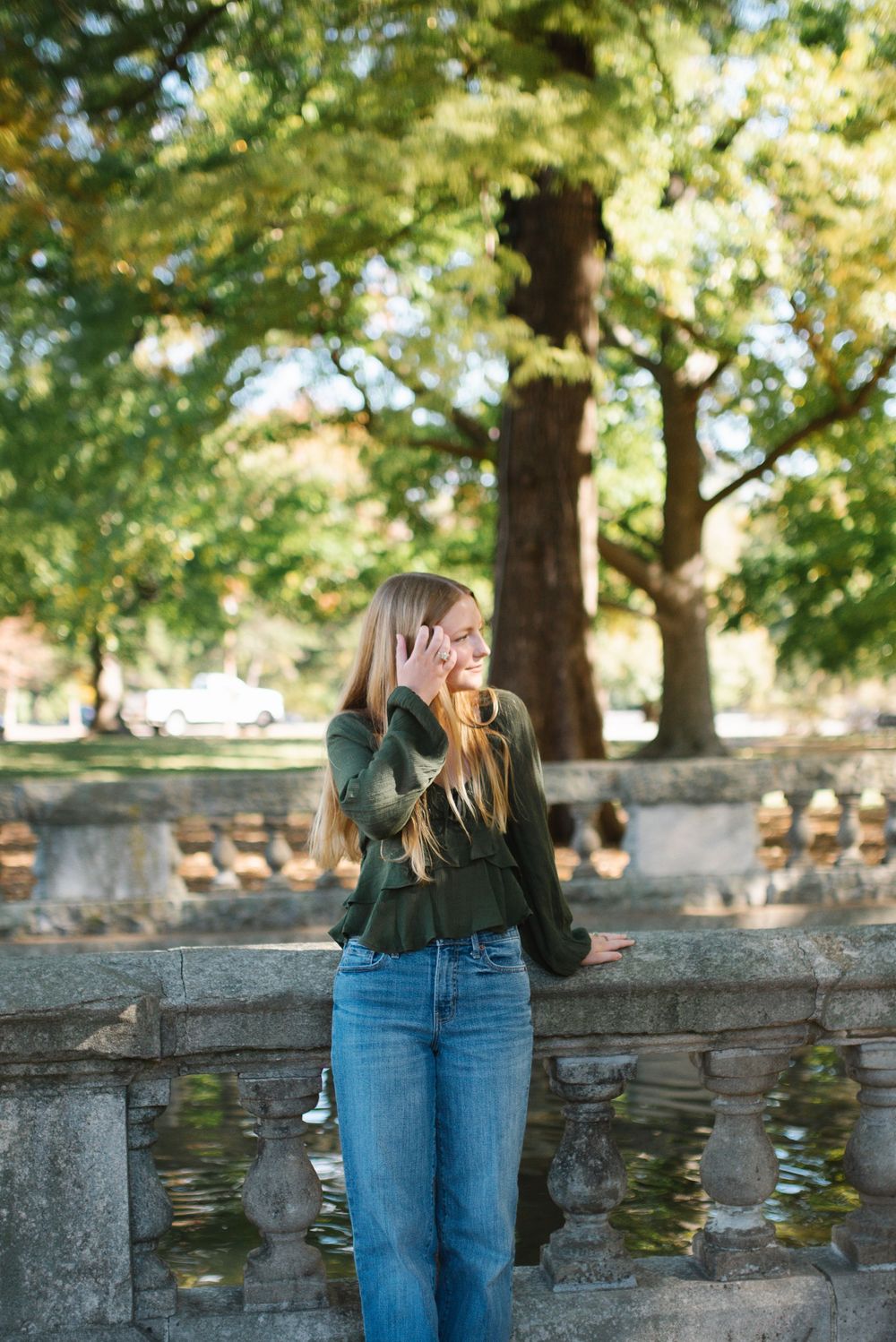 Candid moments captured along a stone wall in a sunlit park setting.