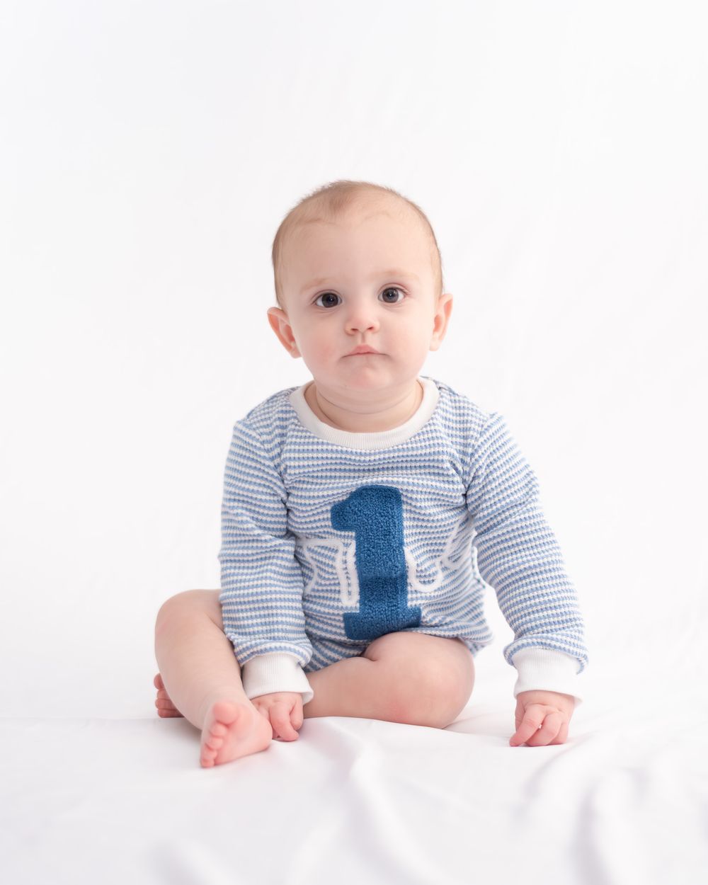 One year old boy sitting for milestone session with a Belton Texas baby photographer