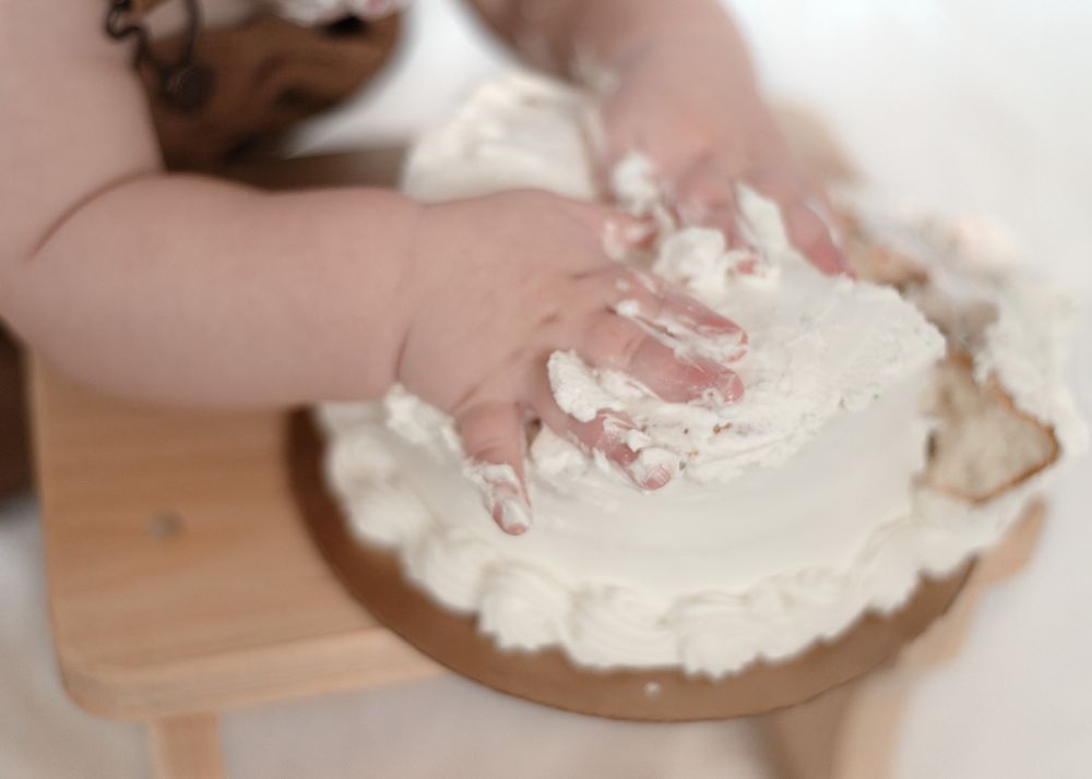 One year old boy smashing cake during milestone session with a Harker Heights Texas baby photographer.