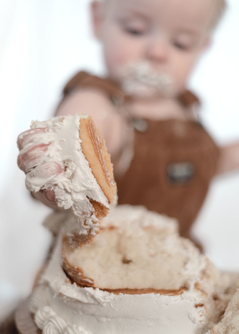 One year old boy smashing cake during milestone session with a Harker Heights Texas baby photographer.