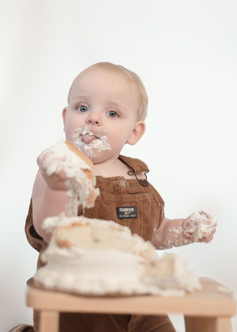 One year old boy smashing cake during milestone session with a Harker Heights Texas baby photographer.