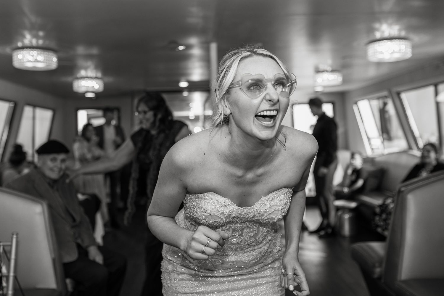 A collection of black and white photos showing joyful moments at a wedding reception with dancing and celebrations on a boat in San Diego.